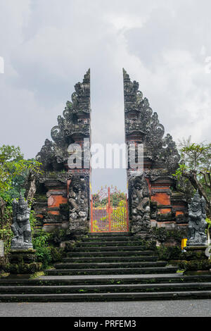 Big stone gate - traditional entrance to Hindu temple with statues on sides in Ubud, Bali Stock Photo