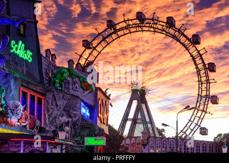 Wien, Vienna: Riesenrad (Ferris Wheel, giant wheel), creepy house 'Geisterschloss' in Prater Amusement park, fiery sunset, 02. Leopoldstadt, Wien, Aus Stock Photo