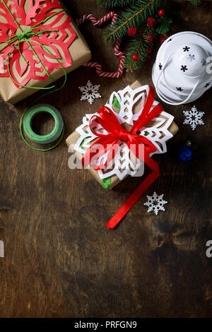 Christmas background. Xmas gift box, branch of a Christmas tree and decorations on rustic background. Top view flat lay background. Copy space. Stock Photo