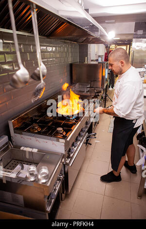 Chef cooking and doing flambe on food in restaurant kitchen , Great cook at work Stock Photo