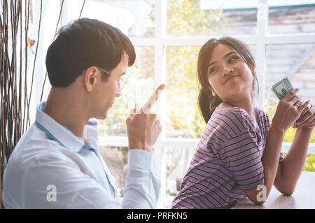 Husband is angry on greedy wife stealing money Stock Photo