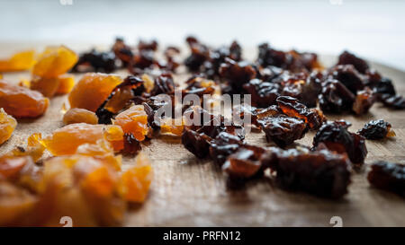 Healthy Diet Food Ingredients: Chopped Dried Apricots And Prunes On A Wooden Cutting Board. Stock Photo