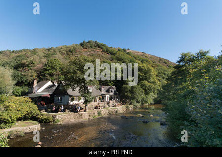 Fingle Bridge Inn next to the river Teign in Dartmoor with people outside eating and drinking Stock Photo