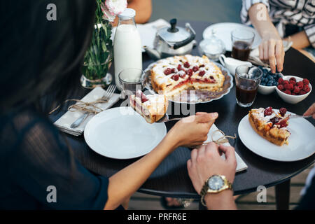 Enjoying pie with friends. Group of people having breakfast together. food, eating and family concept Stock Photo