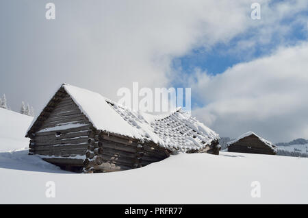 Winter landscape with old wooden destroyed house. Shepherds hut in a mountain valley. Carpathians, Ukraine, Europe Stock Photo