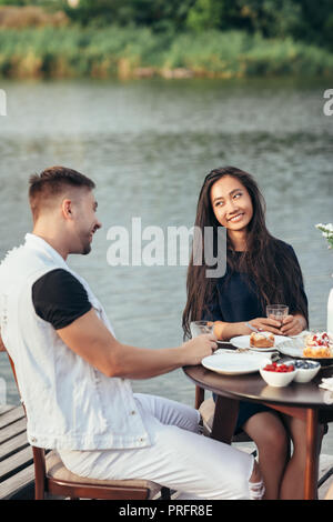 Happy loving couple enjoying breakfast in nature. Love, dating, food concept Stock Photo