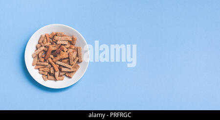 Appetizing rusks to beer on the plate. Copy space. Isolated on blue. Stock Photo
