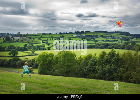 A boy flying a kite in the west country,UK Stock Photo