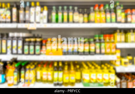 colorful supermarket shelf with bottles blurred as image background Stock Photo