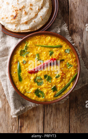 Indian popular food Dal Tadka Curry served with roti flatbread close-up on the table. Vertical top view from above Stock Photo