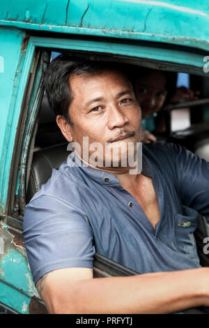 Portrait of Balinese man driving and daughter in Bali, Indonesia Stock Photo