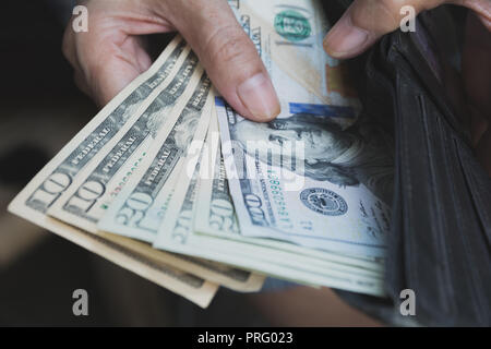 Hand holding a banknote in wallet for financial, accounting and saving money concept. Stock Photo