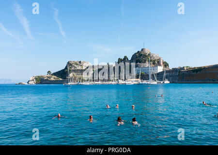 People swimming in the sea near to the Old Venetian Fort in Corfu Town, Corfu, Greece Stock Photo