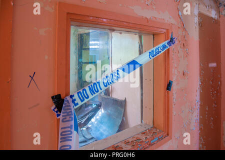 Police cordon tape across a window Stock Photo