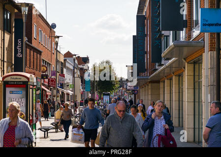 View along Burleigh Street with shoppers walking along the pavement, Primark and the Grafton Centre line the street, Cambridge, UK Stock Photo