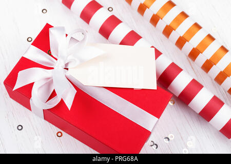 Flat lay concept for Christmas gift wrapping with beautiful red and white  striped gift box with big red bow, wrapping paper, ribbons, and decoration  l Stock Photo - Alamy