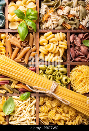 Assorted colorful italian pasta in wooden box Stock Photo