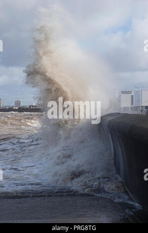 Waves from high tides crash over the promenade at New Brighton on The Wirral, U.K. Stock Photo