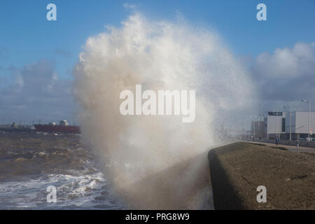 Waves from high tides crash over the promenade at New Brighton on The Wirral, U.K. Stock Photo