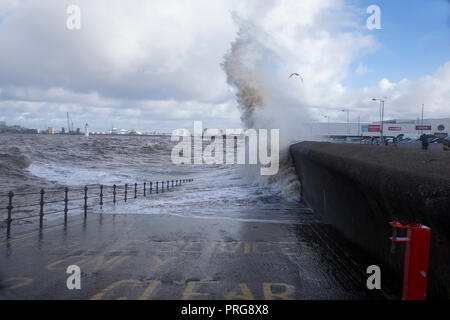 Waves from high tides crash over the promenade at New Brighton on The Wirral, U.K. Stock Photo