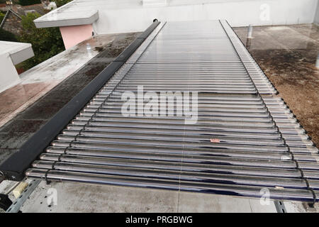 Solar water heating tubes on building roof Stock Photo