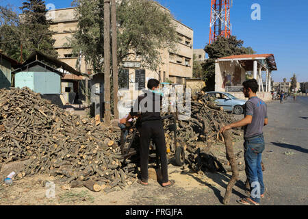 September 14, 2018 - Syrians in the city of Idlib chop forest wood with a chainsaw to prepare firewood for heating. Many Syrians resort to logs for heating as with the conflict the price of diesel has risen from approximately $28 to approximately $100 per barrel, accompanied by a ten-fold devaluation of the Syrian currency. Before the onset of the conflict kerosene was mainly used in heating during the winter season in Idlib, but since the conflict started many Syrians have resorted to cutting down trees from nearby forests and woodlands to stay warm while facing fuel rocketing prices and fue Stock Photo