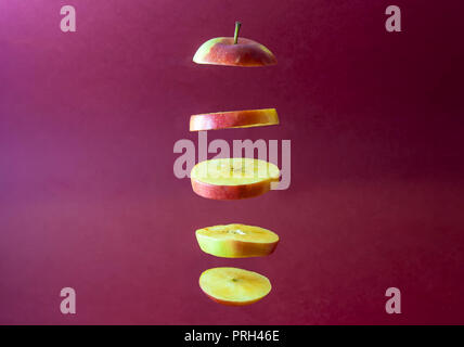 Flying Apple slices with red background Stock Photo