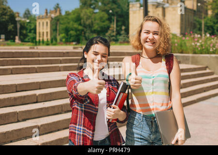 Thumbs up Two happy students. Stock Photo