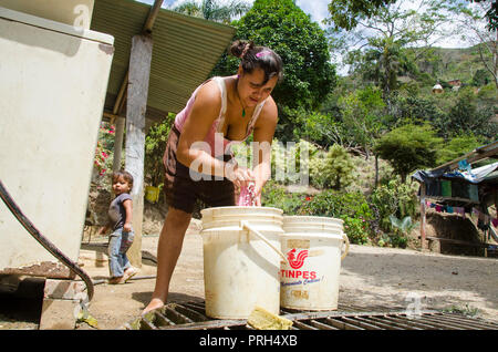 The shortage of basic services is common in rural areas of extreme poverty. A woman washes her family's clothes by hand, with water collected from the Stock Photo