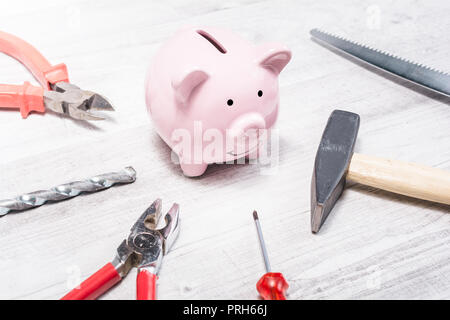 Pink Piggy Bank Surrounded By Tools Like Hammer, Pliers Or Saw - Open Piggybank Concept Stock Photo