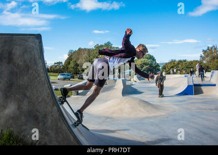 A skateboarder performing a skateboarding trick on a quarter pipe at Concrete Waves in Newquay in Cornwall. Stock Photo