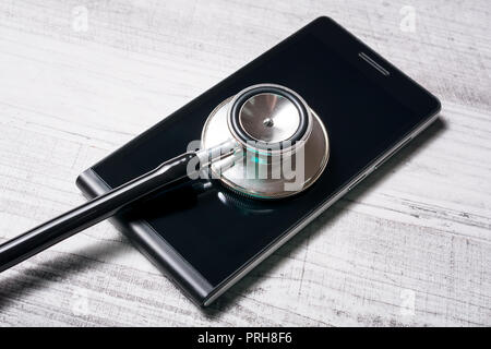 Stethoscope On A Black Smartphone - Repairing A Broken Mobile Phone Concept Stock Photo