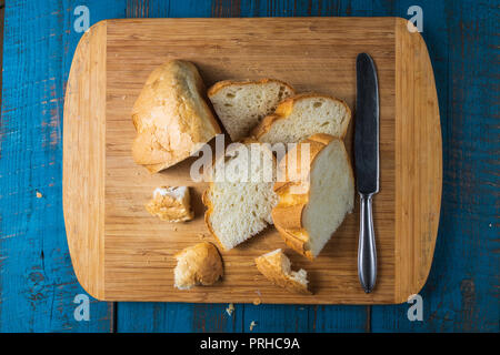 Flat lay view of Baked homemade white wheat bread on old blue wooden desk. Stock Photo