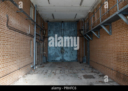 Hydraulically operated steel gates inside the vehicle bay of a prison. Stock Photo