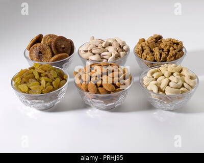 Dryfruits and nuts in six bowls shot against a white background Stock Photo