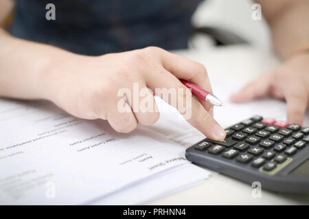 Man is using calculator with holding pen in hand. Stock Photo