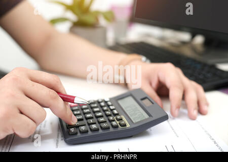 Man is using calculator with holding pen. Stock Photo