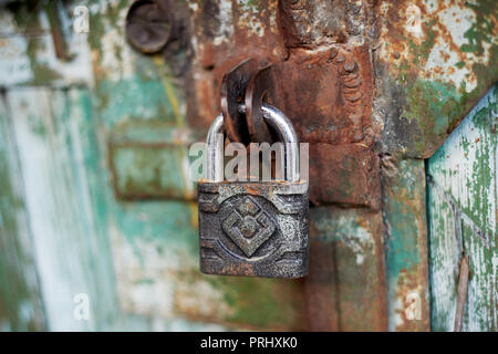 Old metallic padlock on wood,I have not painted the gate. Green shabby paint. Stock Photo