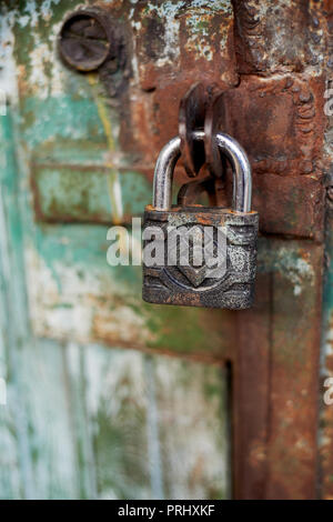 Old metallic padlock on wood,I have not painted the gate. Green shabby paint. Stock Photo