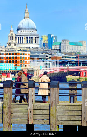 People looking towards St Paul's Cathedral from one of the wooden piers on Gabriel's Beach, South Bank, London, England, UK. Stock Photo