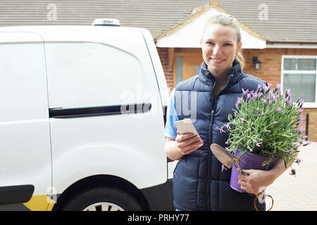 Portrait Of Woman Running Mobile Gardening Business Using Mobile Phone Stock Photo