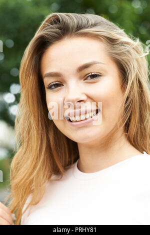 Outdoor Head And Shoulders Portrait Of Smiling Teenage Girl Stock Photo
