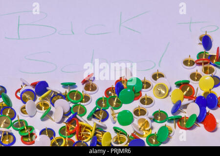 thumbtacks scattered on a white paper with the words "back to school", horizontal image Stock Photo