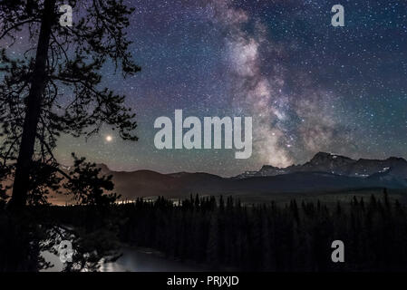 The Milky Way and Galactic Centre (right) and Mars (at left, near its brightest for 2018), over the Bow River and Bow Valley, looking south and west t Stock Photo