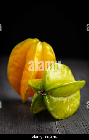 ripe yellow and green star fruit carambola or star apple ( starfruit ) on dark background Stock Photo