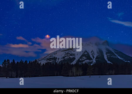 The total eclipse of the Moon over a peak of the Continental Divide at the Crowsnest Pass area of the Canadian Rocky Mountains in southwest Alberta, b Stock Photo