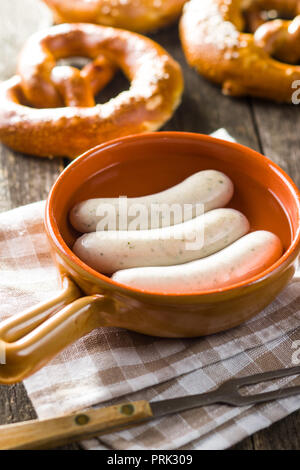 The bavarian weisswurst, pretzel and mustard in pot with water. Stock Photo
