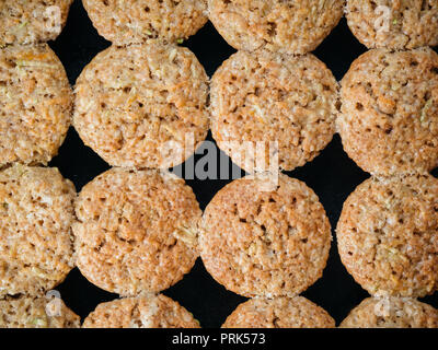 Top view of homemade vegetables muffins in baking tray. Close up view of cupkaces with zucchini, carrots, apple and cinnamon on black background. Sweet vegetables homemade muffins Stock Photo