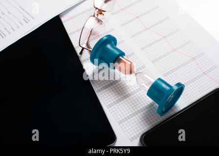 hourglass, statistics graph on the table with a tablet and phone Stock Photo
