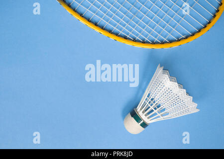 Close up shuttlecock and badminton racket on blue background. Stock Photo